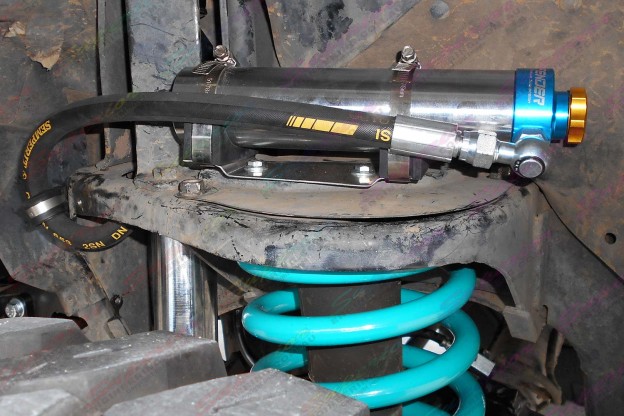 Profender 4x4 Remote Res shock mounted to the top of the coil tower and some heavy duty blue coil springs