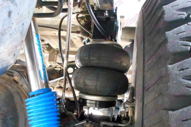 Closeup view of a single leaf helper spring and air hose and superior shocks fitted to the 76 Series Landcruiser