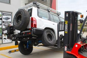 Rear view of the boys testing out the flex of the GU Nissan Patrol wagon with the forklift at the front of the Superior Engineering 4x4 retail showroom at Deception Bay
