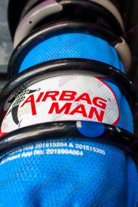 Closeup view of the airbag man coil helper and kevlar protection bag inside some black coil springs