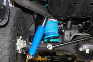 Closeup underside view of the GU Nissan Patrol showing a single Airbag Man airbag, Dobinsons coil spring, Superior coil retainer and Superior remote reservoir shock